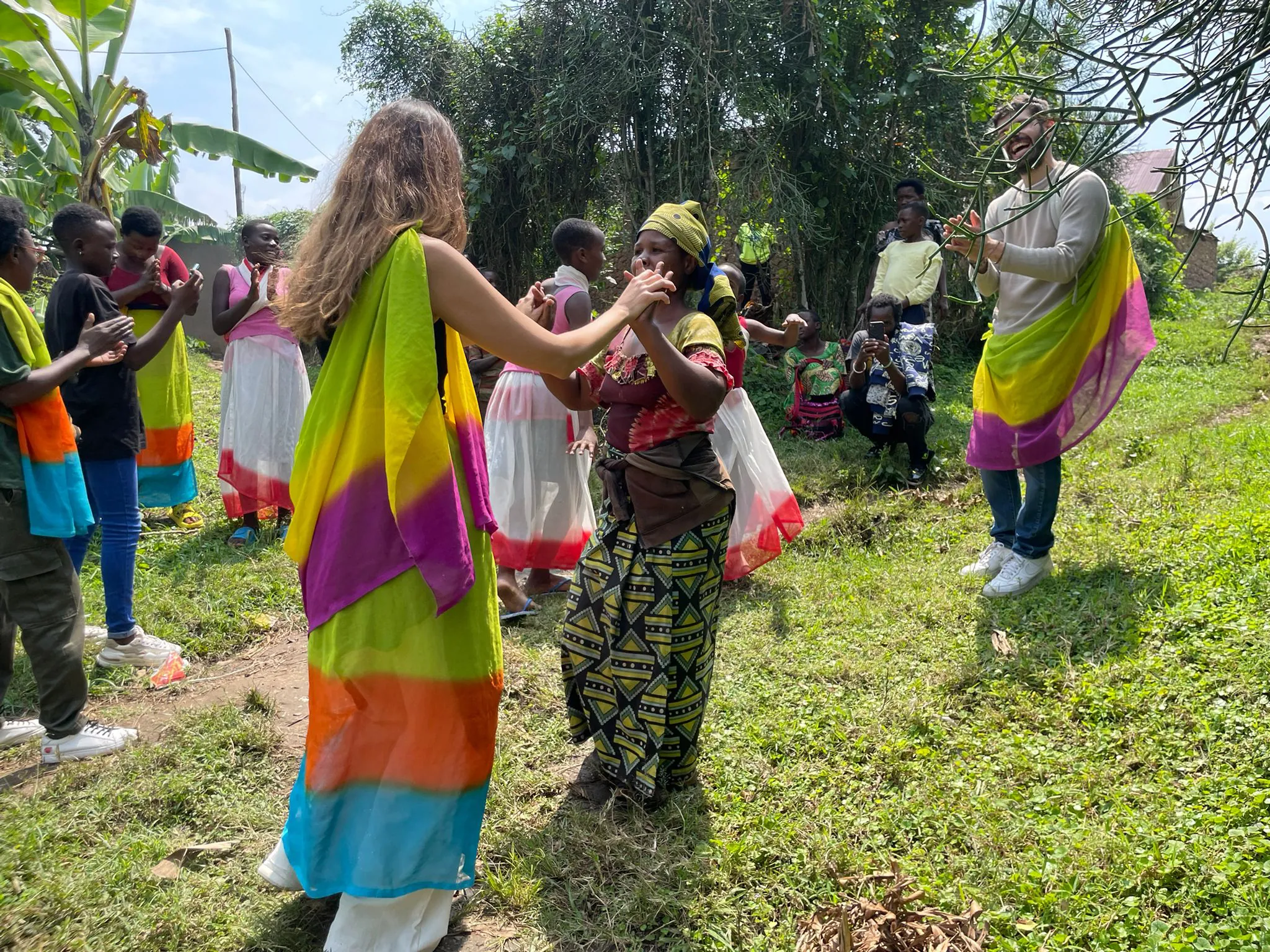 Kelly's guests dancing with local Rwandan women in traditional colourful sashes